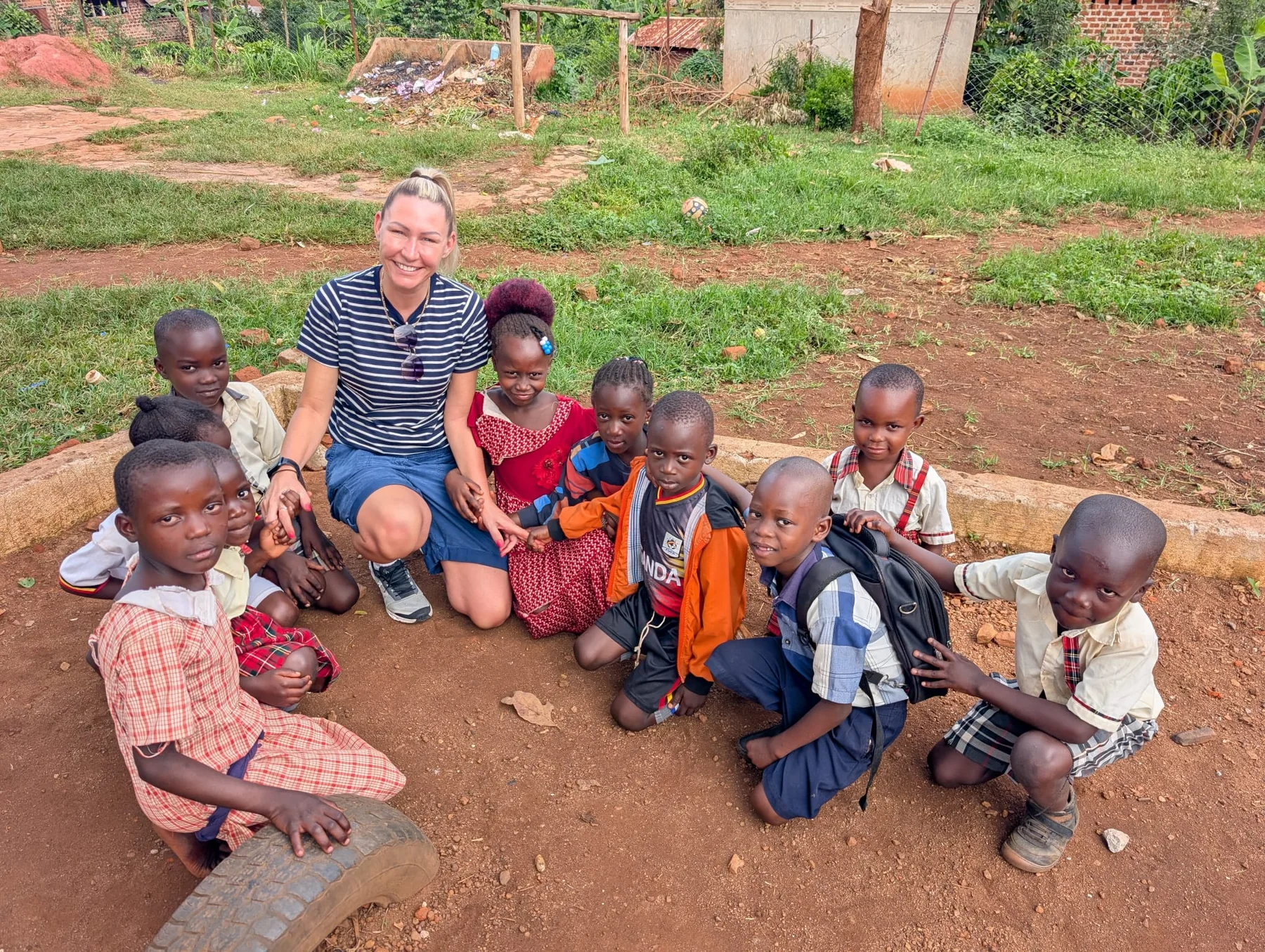 Visiting team member sitting with primary pupils outdoors